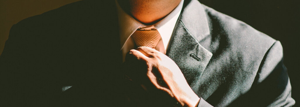 A black man straightening his tie