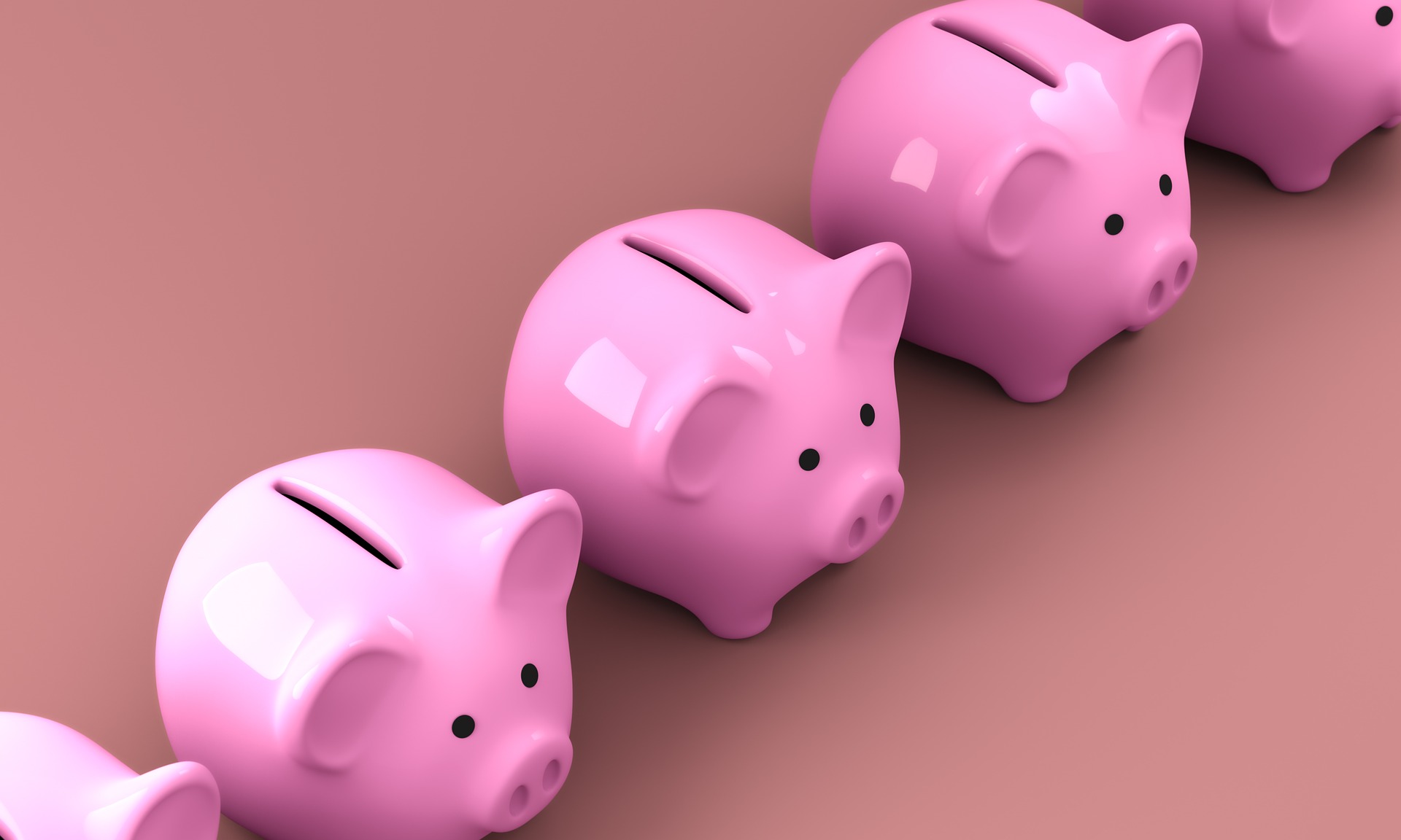 Five pink piggy banks in a row