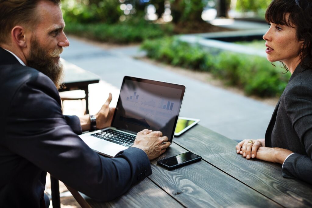 Two coworkers discussing data on a computer.