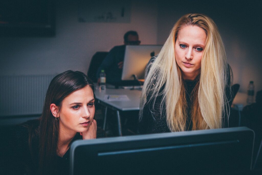 Two coworkers looking at a computer screen.