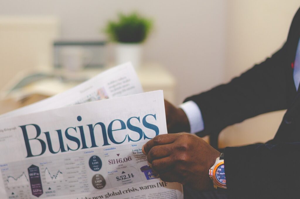 A man holding a Business newspaper.