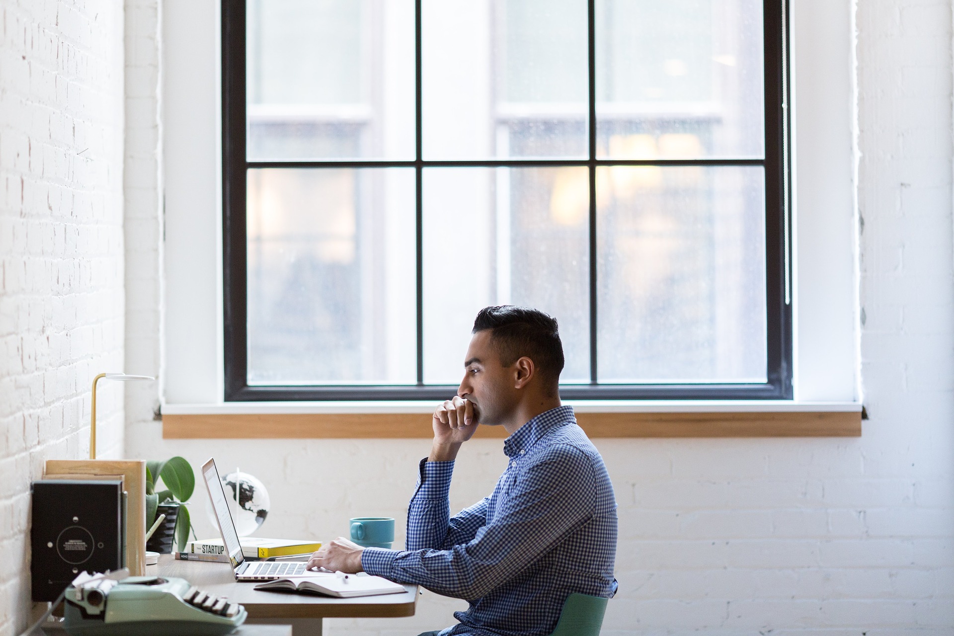 A businessman sitting at his desk on a laptop.