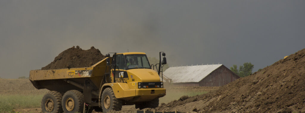 A dump truck filled with a load of dirt.