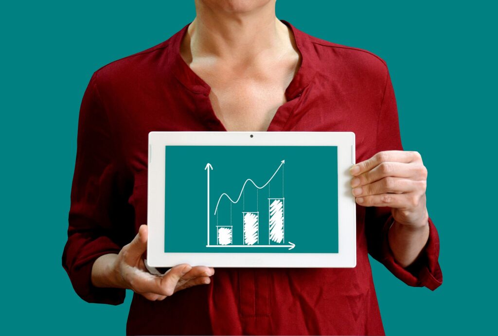 A woman holding a bar graph with bars steadily increasing.