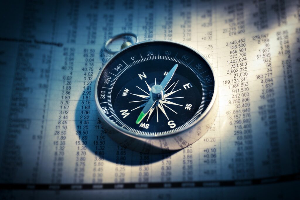 A compass on top of a money ledger.